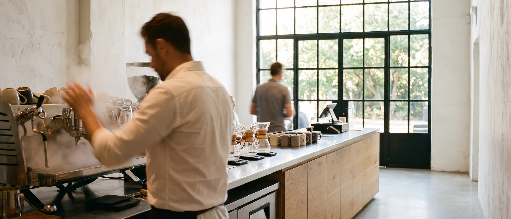 A barista working the machine along the full length of the counter